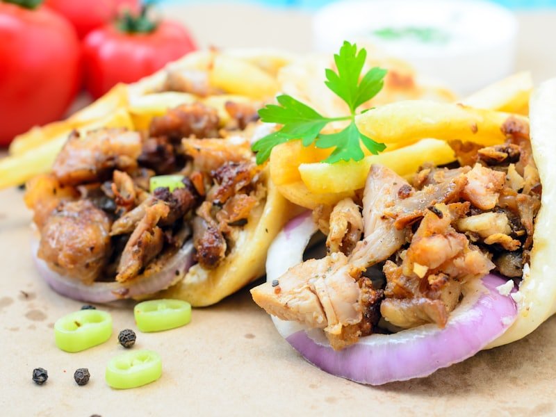 Two doner kebab wraps filled with carved meat, red onion and salad